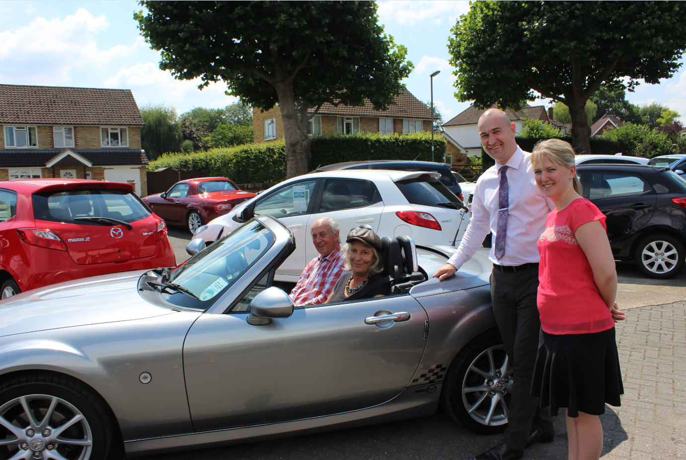 Adrian Arnold, Sales Executive and Amy Paterson, Marketing Manager, wave off Mr and Mrs Wetton in their new MX-5