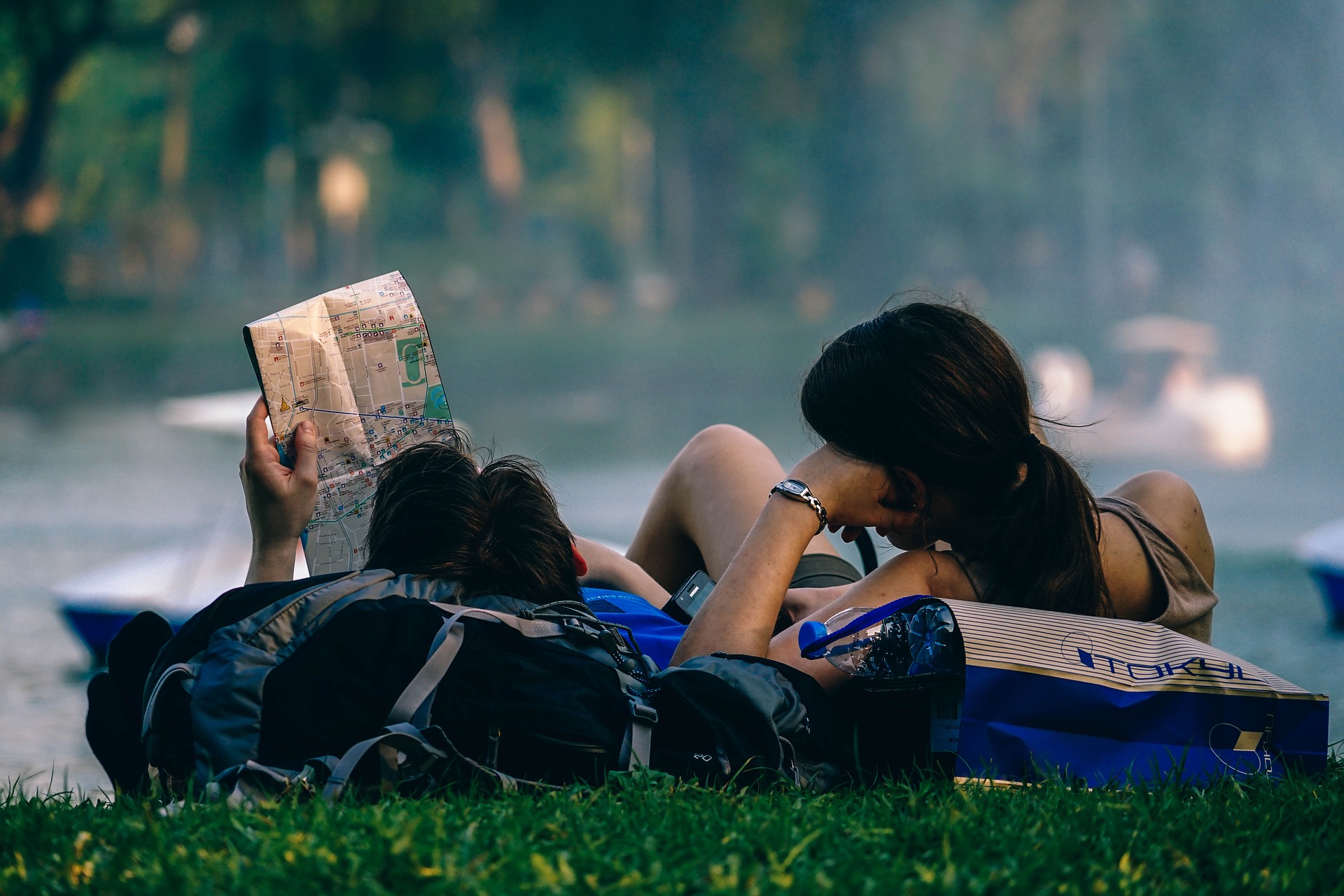 couple relaxing by lake with map